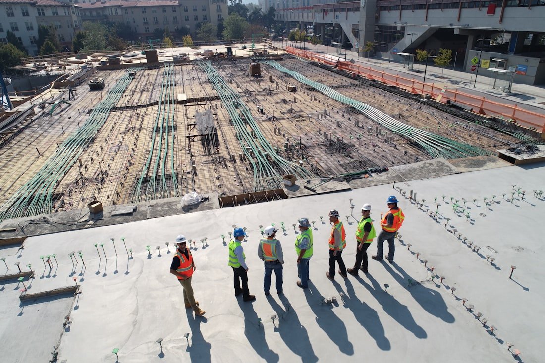 Reinforced concrete deck under construction, site team walking the slab